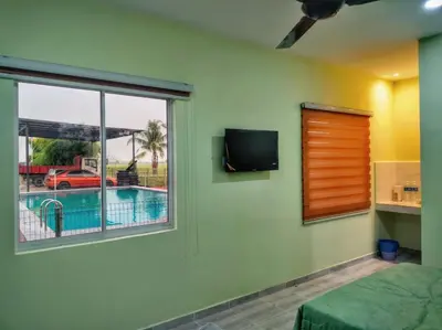 a bedroom with a window and a view of a pool at Inapan Tepi Sawah