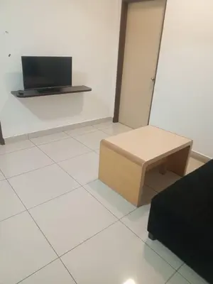a room with a table and a tv on a wall at Marina sunset view in Lumut