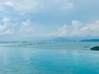 a swimming pool with a bridge in the water at Premium Comfort Rooftop View bayan lepas airport 9pax in Bayan Lepas