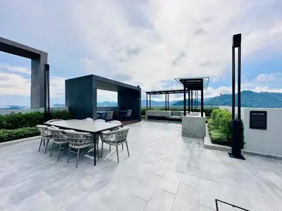 a patio with a table and chairs on a building at High Rise Haven 3BR Rooftop Pool Stylish Comfort 9pax in Bayan Lepas