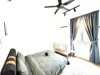 a bedroom with a bed and a couch and a window at Gioia Home Two Taiping Town in Taiping