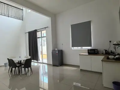 a kitchen with a table and a tv in a room at Padang Serai Wangi Roomstay 91 in Padang Serai