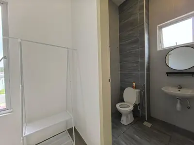 a bathroom with a toilet and a sink and a mirror at Padang Serai Wangi Roomstay 91 in Padang Serai