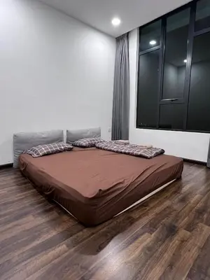 a large bed in a room with a wooden floor at Kuching Town Area Rex apartment in Gua Sai