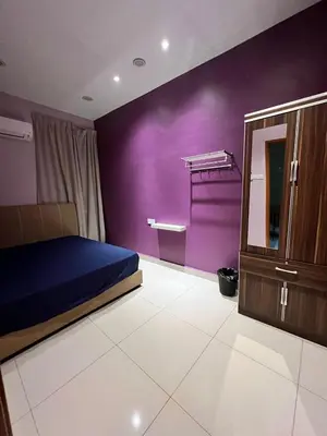 a bedroom with purple walls and a bed and a dresser at Alma Sweet Home in Bukit Mertajam