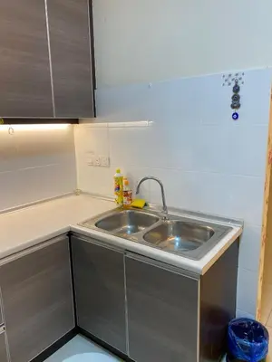 a kitchen with a stainless steel sink and cabinets at 11th Sky Kinta Riverfront with Wi-Fi in Ipoh