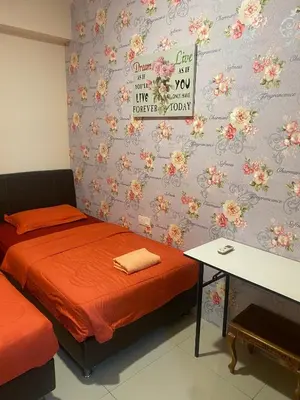 a room with two beds and a wall with flowers at 11th Sky Kinta Riverfront with Wi-Fi in Ipoh