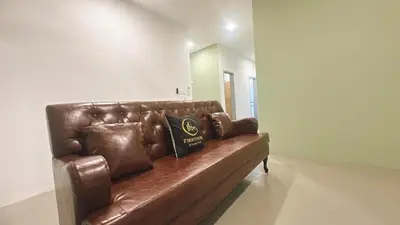 a brown leather couch sitting in a living room at 2 Bedroom Townhouse Homestay In Bandar Dato Onn in Gua Sai