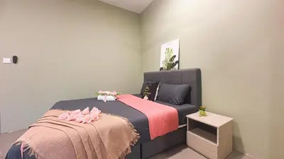a bedroom with two beds with pink sheets and a table at 2 Bedroom Townhouse Homestay In Bandar Dato Onn in Gua Sai