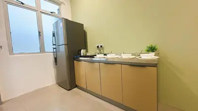 a kitchen with a counter with a refrigerator at 2 Bedroom Townhouse Homestay In Bandar Dato Onn in Gua Sai