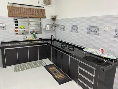 a kitchen with a black counter top in a room at Homestay Aman Berkat in Kampar