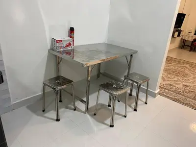 a table with two stools and a table with a counter at Homestay Aman Berkat in Kampar