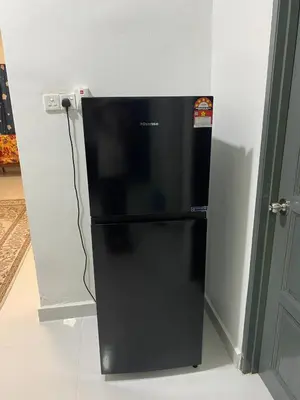 a black refrigerator with its door open in a room at Homestay Aman Berkat in Kampar