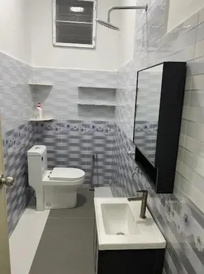 a bathroom with a toilet and a sink and a mirror at Homestay Aman Berkat in Kampar
