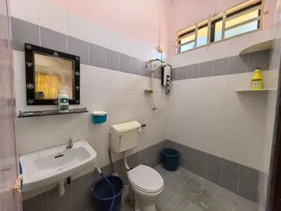 a bathroom with a toilet and a sink at Lagenda Serai Wangi Homestay in Padang Serai