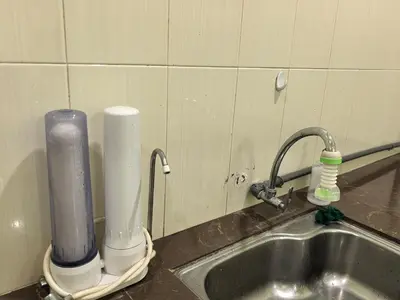 a kitchen sink with a faucet next to a sink at Lagenda Serai Wangi Homestay in Padang Serai