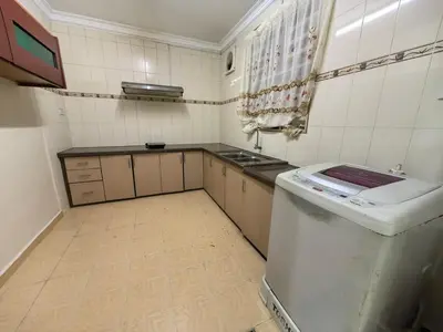 a kitchen with a stove and a sink in it at Lagenda Serai Wangi Homestay in Padang Serai