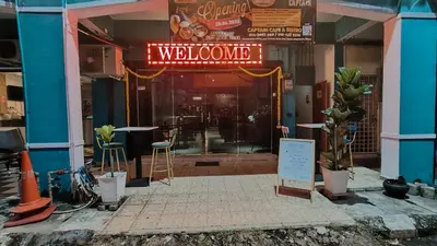 a welcome sign in the doorway of a restaurant at Captain Hotel Cafe & Bistro in Sitiawan