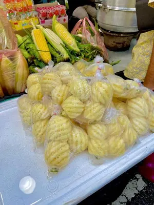 a pile of peeled corn in plastic bags on a table at Lily Studio in Brinchang