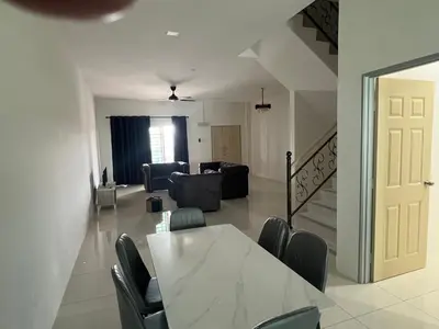 a dining room and living room with a table and chairs at Homestay Behrang Sentral in Kampung Behrang