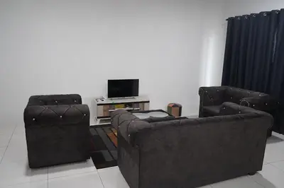 two chairs and a television in a living room at Homestay Behrang Sentral in Kampung Behrang