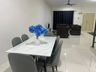 a white table with chairs and a vase with blue flowers at Homestay Behrang Sentral in Kampung Behrang