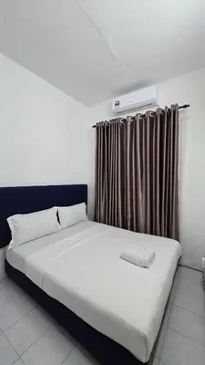 a bed in a room with a window with a white mattress at Anjung Vacation Home No 70 in Gua Sai