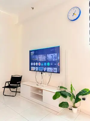 a living room with a tv on a white wall at The Sun Executive Suite - Dolphin's Home in Bayan Lepas