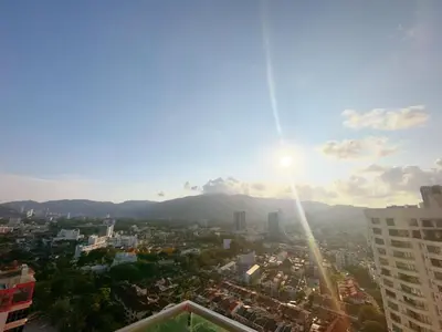a view of a city with the sun in the sky at Mansion One studio in George Town