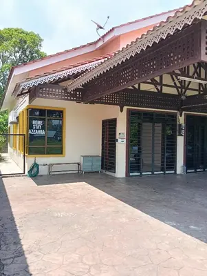 a building with awning and a bench on a patio at Azzahra Homestay in Permatang Pauh