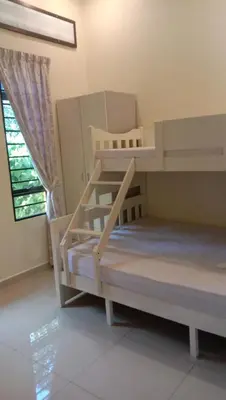 two bunk beds in a room with a window at Azzahra Homestay in Permatang Pauh