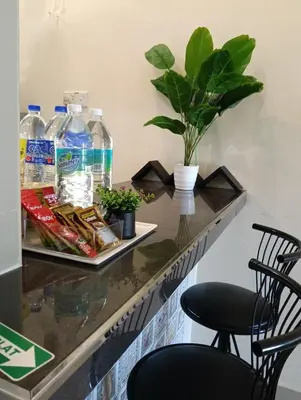 a bar with two chairs and water bottles on a counter at Azzahra Homestay in Permatang Pauh