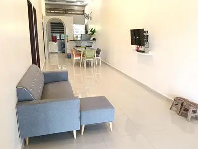 a living room with a blue couch and a table at Azzahra Homestay in Permatang Pauh