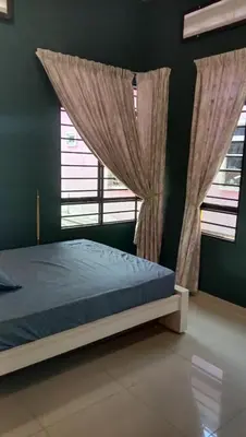 a bedroom with a bed and a window with curtains at Azzahra Homestay in Permatang Pauh