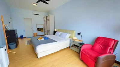 a bedroom with a bed and a red chair at PPAM Seruling Presint 5, Putrajaya 4BR with PICC View and Garden View Homestay