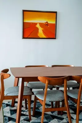 a wooden table and chairs with a painting on the wall at Lotus Lake Sanctuary Homestay Taiping With Netflix -1 Carpark in Taiping