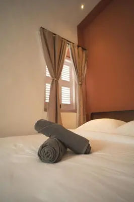 a towel laying on a bed in front of a window at Carnarvon 73 in George Town