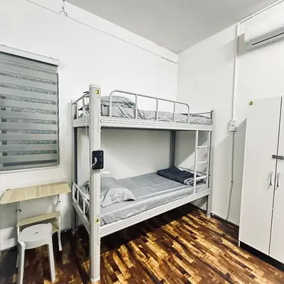 a bedroom with two bunk beds and a desk at Hey Rest Up with shared bathroom in Ipoh