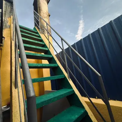a staircase with green steps next to a fence at Hey Rest Up with shared bathroom in Ipoh