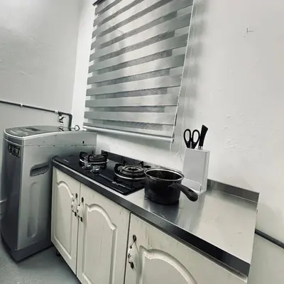 a kitchen with a stove and a sink with scissors at Hey Rest Up with shared bathroom in Ipoh