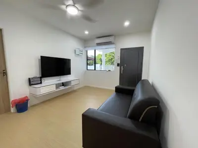 a living room with a black couch and a flat screen tv at Ling Dream Home in Sitiawan in Sitiawan