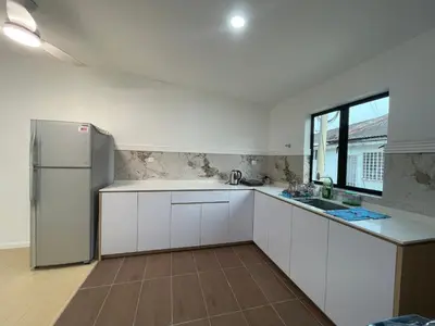 a kitchen with white cabinets and a refrigerator at Ling Dream Home in Sitiawan in Sitiawan