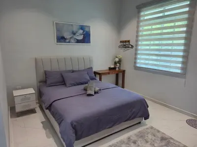 a bedroom with a bed with a stuffed animal on it at NAR Kampung Studio in Bayan Lepas
