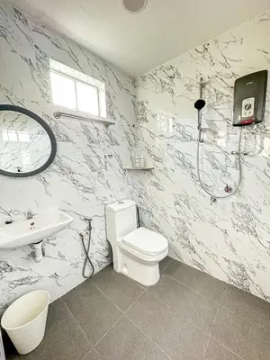 a bathroom with a shower and a toilet and a sink at NAR Kampung Studio in Bayan Lepas