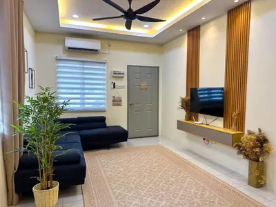 a living room with a blue couch and a tv at Hana Homestay Seri Iskandar in Seri Iskandar