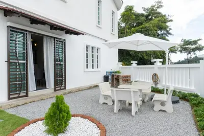 a patio with a table and an umbrella at Leavy Haven, Botanica CT, Balik Pulau, Penang in Balik Pulau