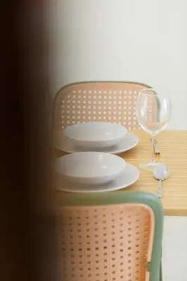 a table with two white plates and a wine glass at De Luma-Cozy 2Bedroom Landed House, Bukit Mertajam in Bukit Mertajam