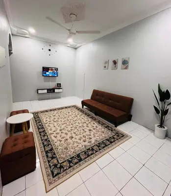 a living room with a couch and a rug at Anuarosi Homestay Taman Melor, Teluk Intan in Teluk Intan