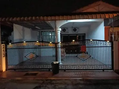 an iron gate with lights on a porch at night at Anuarosi Homestay Taman Melor, Teluk Intan in Teluk Intan