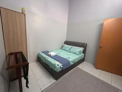 a small bedroom with a bed and a door at Anuarosi Homestay Taman Melor, Teluk Intan in Teluk Intan